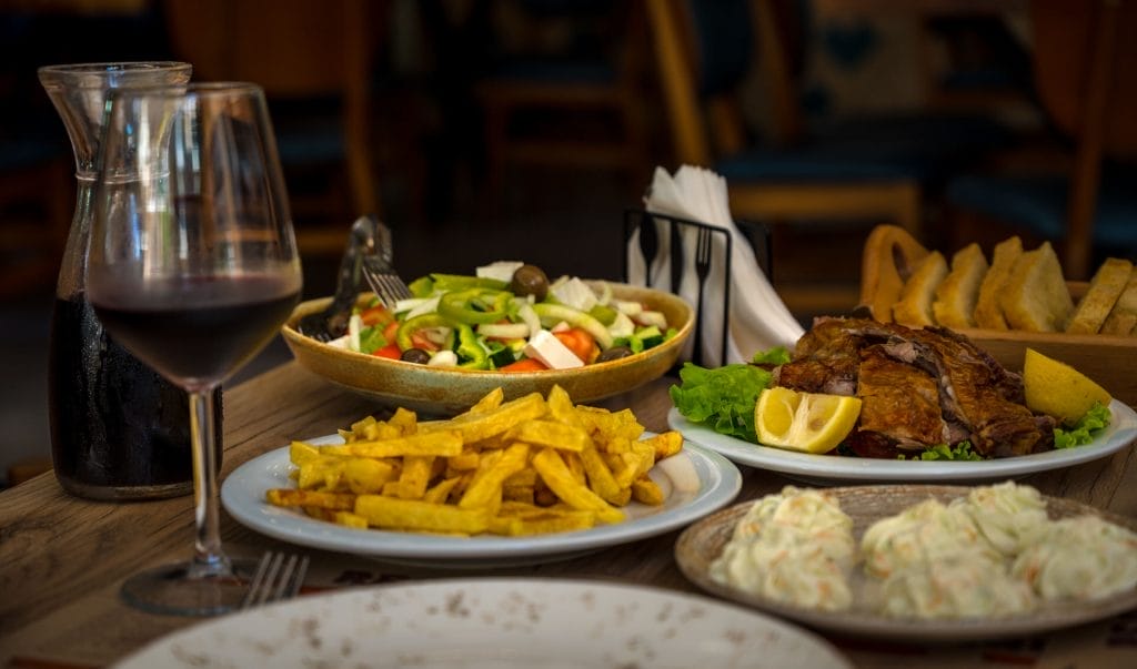 traditional albanian food. restaurant dinner. baked lamb meat with salad, tzatziki and potatoes. High quality photo